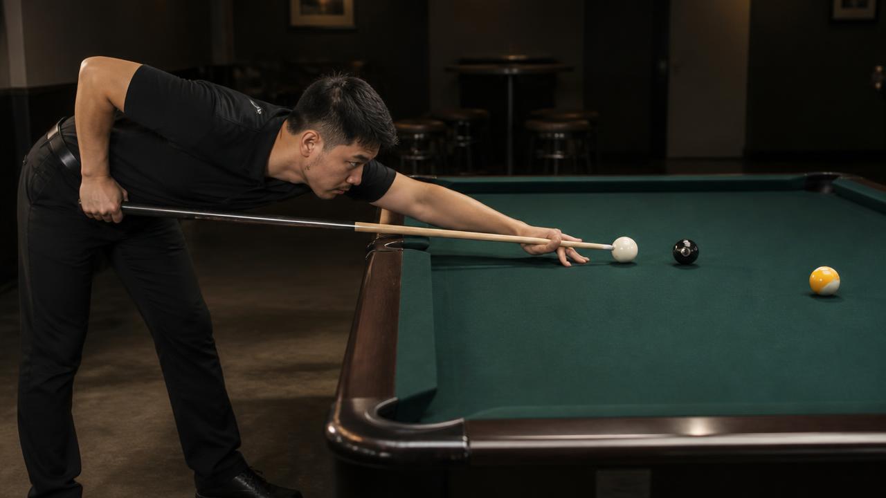 Side view of a player down on a shot with the back arm bent at ninety degrees and the forearm hanging vertical at contact